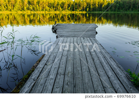 wooden pier. The bridge to the lake under the sunset 69976610