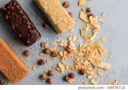small Napoleonic cakes on a gray background with nuts delivery of sweets small Napoleonic cakes on a gray background with nuts delivery of sweets 69976728