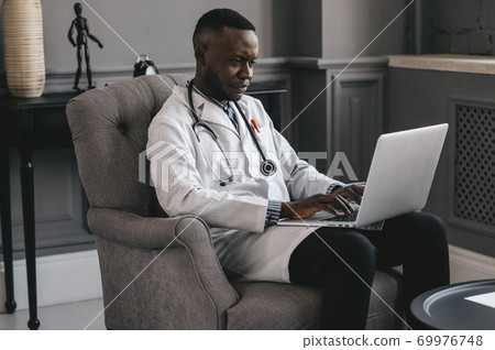 portrait of afro american doctor using laptop computer. online consultation 69976748