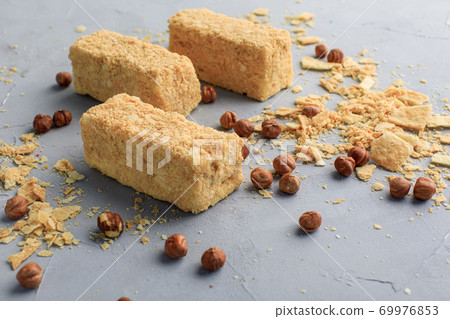 small Napoleonic cakes on a gray background with nuts delivery of sweets 69976853