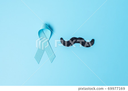 November Prostate Cancer Awareness month, light Blue Ribbon with mustache on wooden background for supporting people living and illness. Farther, international men day and World cancer day concept November Prostate Cancer Awareness month, light Blue Ribbon with mustache on wooden background for supporting people living and illness. Farther, international men day and World cancer day concept 69977169