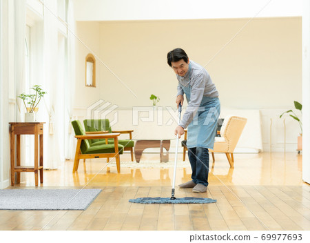 一個六十多歲的男人打掃房間 一個六十多歲的男人打掃房間 69977693