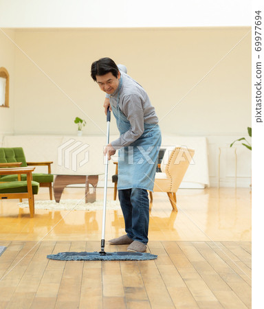 一個六十多歲的男人打掃房間 一個六十多歲的男人打掃房間 69977694