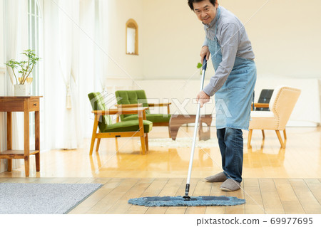A man in his 60s cleaning a room 69977695