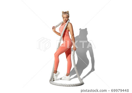 Beautiful young female athlete practicing on white studio background with shadow Beautiful young female athlete practicing on white studio background with shadow 69979448