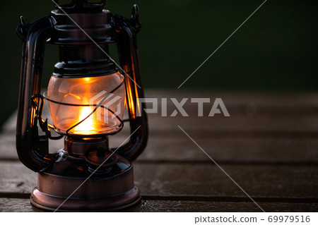 Lantern placed on an outdoor wooden table Lantern placed on an outdoor wooden table 69979516