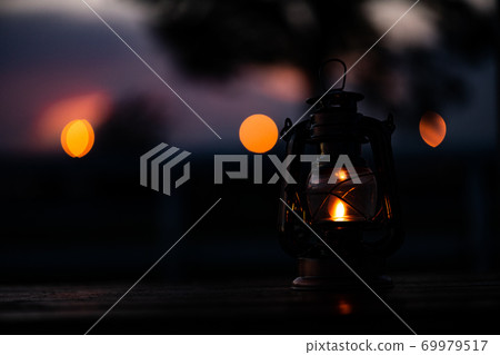 Lantern placed on an outdoor wooden table Lantern placed on an outdoor wooden table 69979517