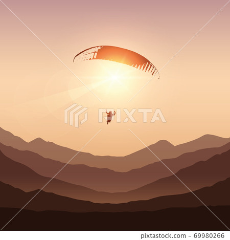 paraglider in sunny sky by sunset in the mountains 69980266