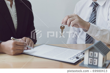 Real estate broker agents advise clients to make a decision to buy a house with insurance. Negotiating purchase-sale and investment planning concept. Real estate broker agents advise clients to make a decision to buy a house with insurance. Negotiating purchase-sale and investment planning concept. 69980413