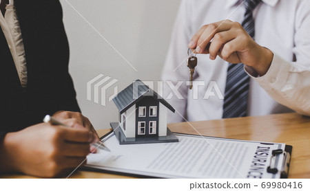 Real estate broker agents advise clients to make a decision to buy a house with insurance. Negotiating purchase-sale and investment planning concept. Real estate broker agents advise clients to make a decision to buy a house with insurance. Negotiating purchase-sale and investment planning concept. 69980416