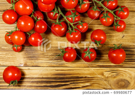Fresh cherry tomatoes on a wooden table. Top view Fresh cherry tomatoes on a wooden table. Top view 69980677