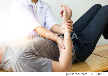 Professional therapists are stretching muscles, patients with abnormal muscular symptoms, physical rehabilitation therapies and treatment of physiological disorders by physiotherapists concept. Professional therapists are stretching muscles, patients with abnormal muscular symptoms, physical rehabilitation therapies and treatment of physiological disorders by physiotherapists concept. 69980735