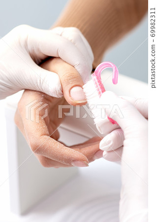 Manicurist removing dust from nails Manicurist removing dust from nails 69982311