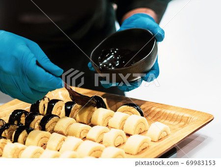 Chef cooking, Chef preparing food in the kitchen, Chef decorating dish, closeup. 69983153