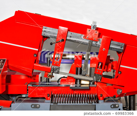 Industrial machine with a band saw for processing large metal parts, close-up. Industrial machine with a band saw for processing large metal parts, close-up. 69983366