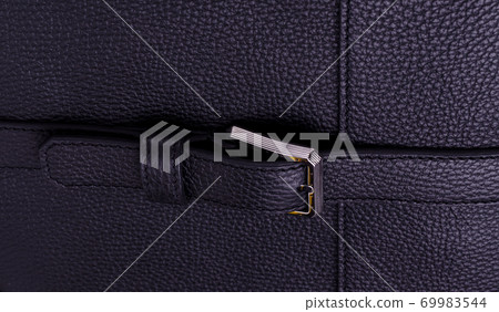 Silver metal clasp on a black leather belt against Genuine leather texture. Silver metal clasp on a black leather belt against Genuine leather texture. 69983544
