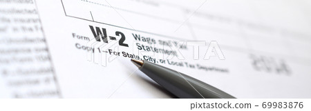 The pen lies on the tax form W-2 Wage and Tax Statement. The time to pay taxes 69983876