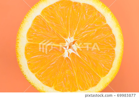 Top view of a one orange fruit slice on bright background in orange color. A saturated citrus texture image 69983877