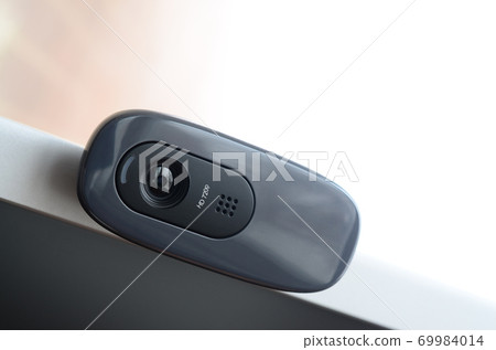 A modern web camera is installed on the body of a flat screen monitor. Device for video communication and recording of high quality video 69984014