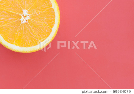 Top view of a one orange fruit slice on bright background in red color. A saturated citrus texture image 69984079