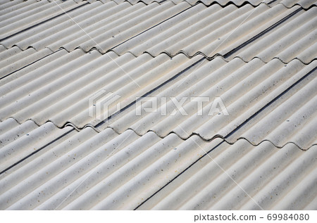 A fragment of a gray slate roof of an old sample made of asbestos material A fragment of a gray slate roof of an old sample made of asbestos material 69984080