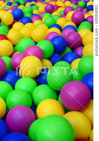 Many colorful plastic balls in a kids' ballpit at a playground. Close up pattern Many colorful plastic balls in a kids' ballpit at a playground. Close up pattern 69984081