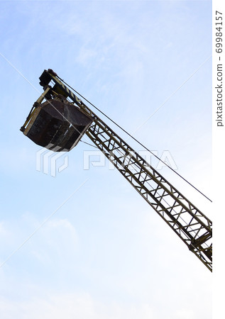 Old yellow mechanical clamshell grab on blue sky background Old yellow mechanical clamshell grab on blue sky background 69984157