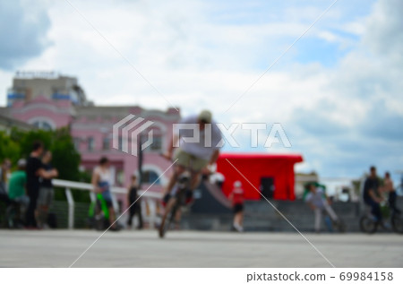 Defocused image of a lot of people with bmx bikes. Meeting of fans of extreme sports Defocused image of a lot of people with bmx bikes. Meeting of fans of extreme sports 69984158