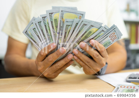 Man counting dollar banknotes on desk. concept of salary,tax and income 69984356