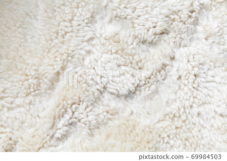 Natural white sheepskin close-up background photo 69984503