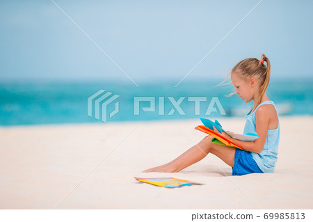 Adorable little girl have fun at tropical beach during vacation Adorable little girl have fun at tropical beach during vacation 69985813