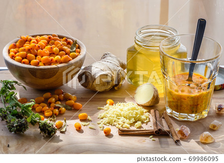 Squeezed sea-buckthorn berries in glass with other ingredients for healthy tea Squeezed sea-buckthorn berries in glass with other ingredients for healthy tea 69986095