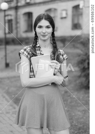 Girl student in skirt and plaid shirt. Black and white photo. BW 69986102