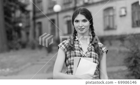 Girl student in skirt and plaid shirt. Black and white photo. BW 69986146