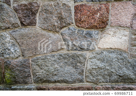 Background of the wall of granite textured stones cemented together Background of the wall of granite textured stones cemented together 69986711