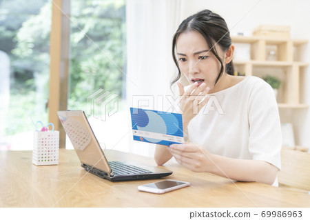 A young woman looking at a passbook A young woman looking at a passbook 69986963