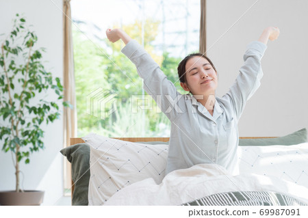 Woman waking up in bed 69987091