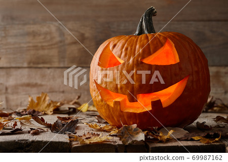 Carved Halloween pumpkin on wooden planks 69987162