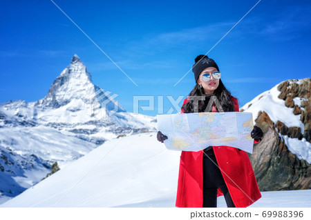 Young female tourist looking map at Matterhorn in Switzerland  69988396