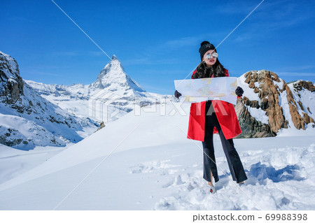 Young female tourist looking map at Matterhorn in Switzerland  69988398