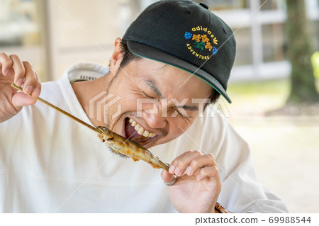 男子吃烤魚 男子吃烤魚 69988544