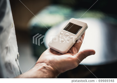 Young man hands hold bio rezonans therapy alternative medicine device, small portable life balance bioresonance for treatment Diseases of the intestinal system Young man hands hold bio rezonans therapy alternative medicine device, small portable life balance bioresonance for treatment Diseases of the intestinal system 69989348