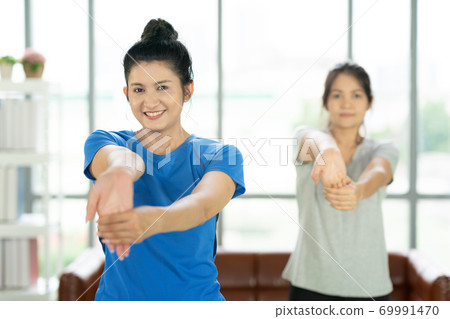Young attractive smiling woman practicing yoga working out, wearing sportswear, Calmness and relax 69991470