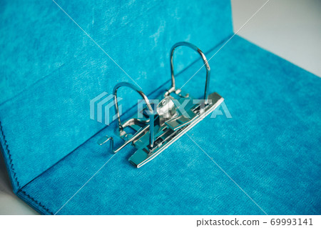 iron latch in a blue folder close-up. accessories in the office iron latch in a blue folder close-up. accessories in the office 69993141