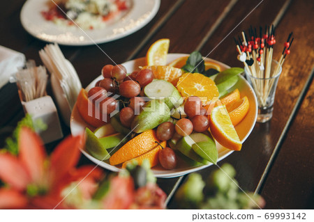 fruit slicing and canapes: pear, grape, orange. Advertising concept for desserts, sweets, cooking, holidays 69993142