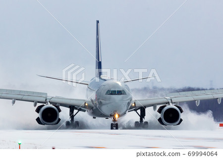 An aircraft that rolls up snow smoke and lands An aircraft that rolls up snow smoke and lands 69994064