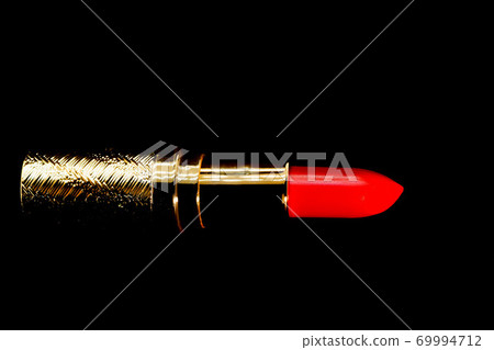 Red lipstick in gold slipcover on black background make up and cosmetic concept Red lipstick in gold slipcover on black background make up and cosmetic concept 69994712