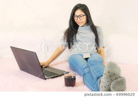 soft selective focus young beautiful asian woman sitting in living room,work online lifestyle,relax at home with coffee,home working laptop,work from home soft selective focus young beautiful asian woman sitting in living room,work online lifestyle,relax at home with coffee,home working laptop,work from home 69996020