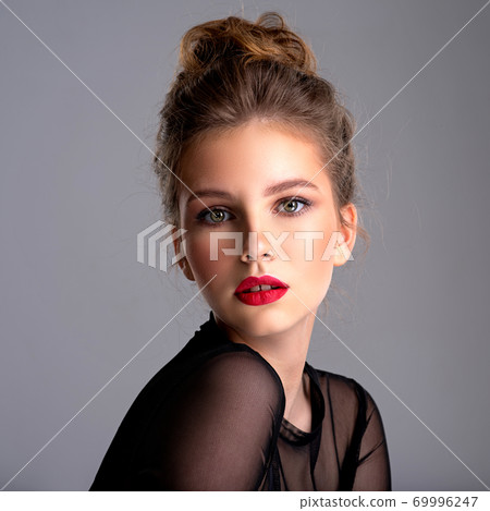 Beautiful photoshopped brown-hair girl. Attractive girl with bright makeup looking at the camera. 69996247