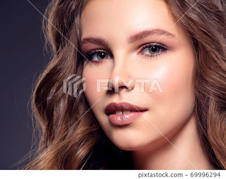 Beautiful brown-hair girl with long hair. Close up of a pretty caucasian girl smiling at camera. Beautiful brown-hair girl with long hair. Close up of a pretty caucasian girl smiling at camera. 69996294